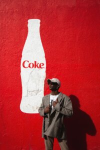 Mural de Coca Cola con Persona al Frente con una gorra