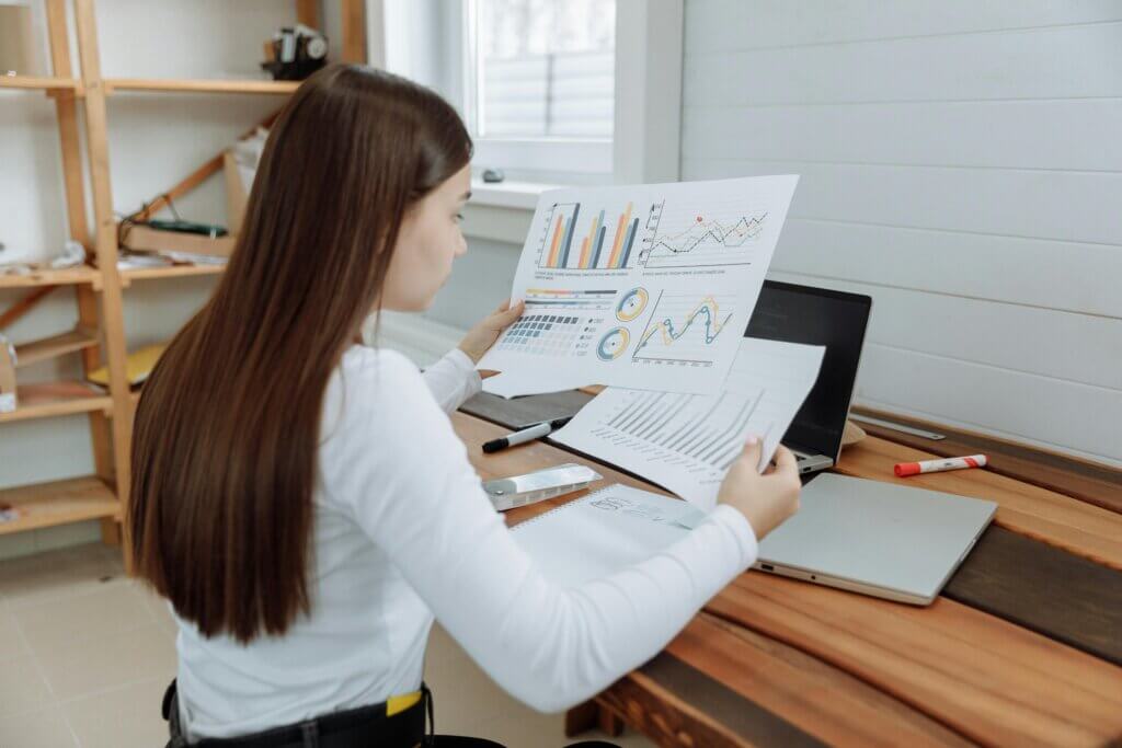 Mujer analizando gráficos y datos en una oficina.